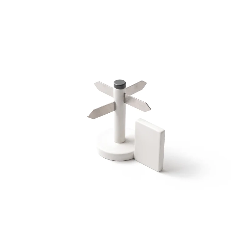 A ceramic signpost with arrow plates and a graphite cap on a round base, a small upright ceramic page tile beside it.
