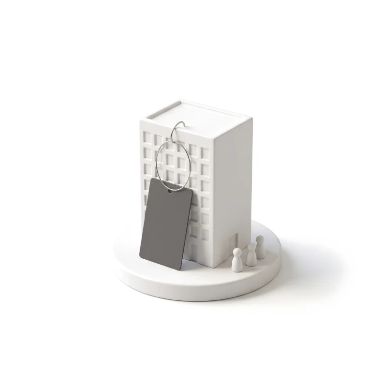 A small white ceramic office building on a round plinth, a graphite key card on a steel ring at its door, three tiny pawns waiting.