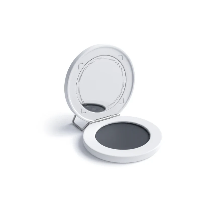 An open ceramic compact on a steel hinge, a face-scan ring and framing brackets in the mirror, a graphite pan below.