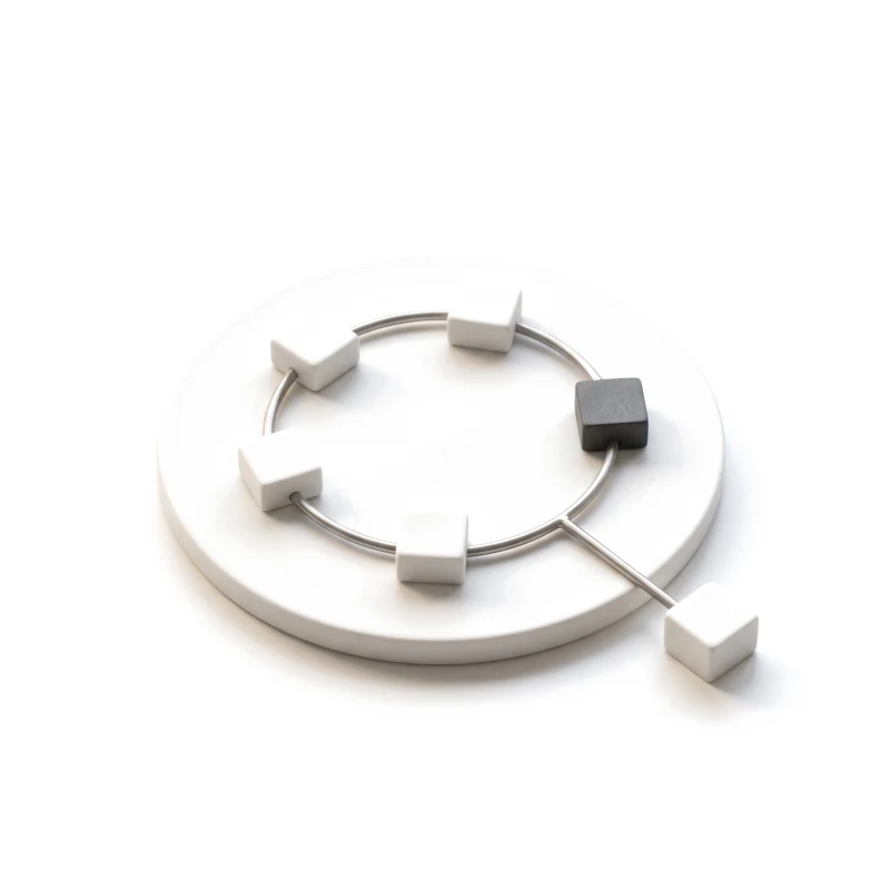 A steel ring on a ceramic plate with white stations, one graphite, and a branch leading off.