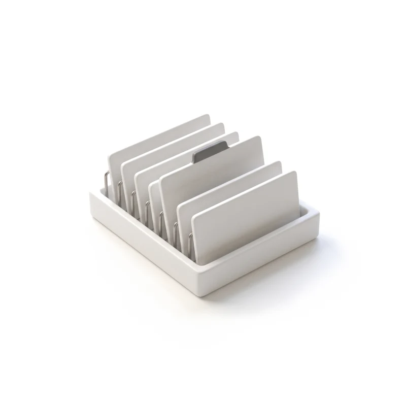 A ceramic in-tray of upright folder cards on steel dividers, one card pulled up with a graphite tab.