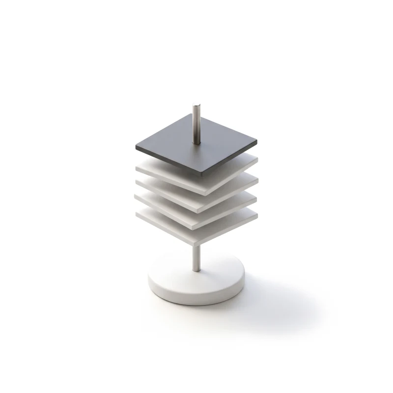 A stack of thin white ceramic image tiles on a steel spindle over a round ceramic base, the top tile in graphite.
