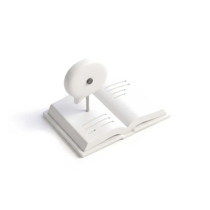 A white ceramic chat bubble on a steel stem above an open ceramic book, a graphite dot set in it.