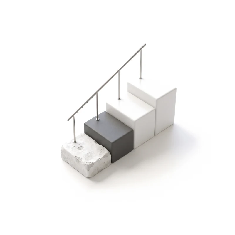 Ceramic steps rising from a rough, chipped block to a smooth new one under a steel handrail, one step in graphite.