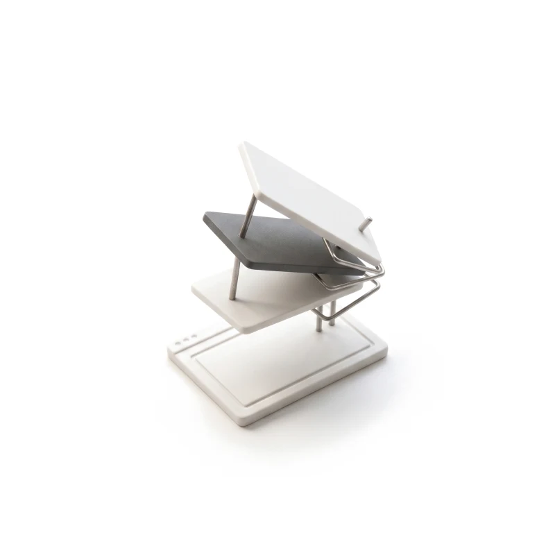 A ceramic browser tile with thin layers lifting off it in a staggered fan on steel pins, one layer graphite.