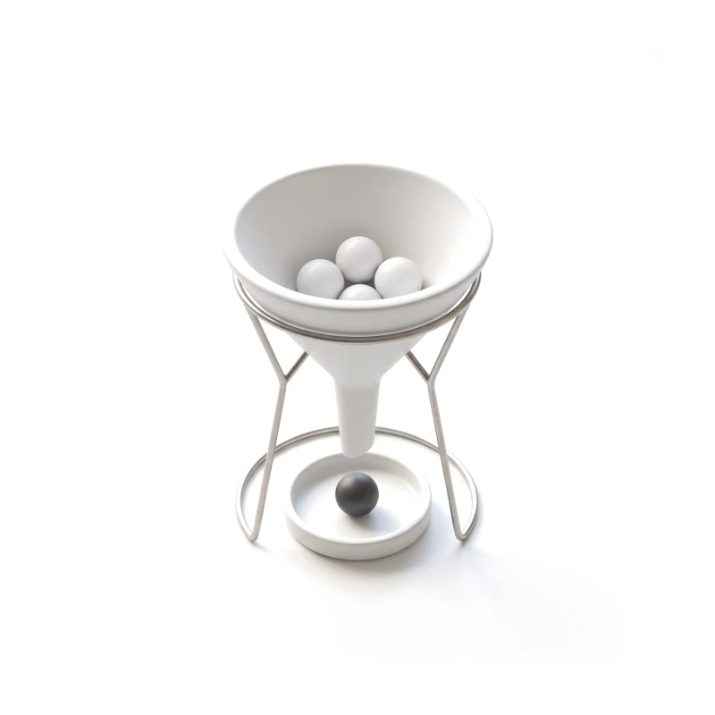 A ceramic funnel on a steel ring stand with three ceramic balls in its mouth and one graphite ball in a dish below.