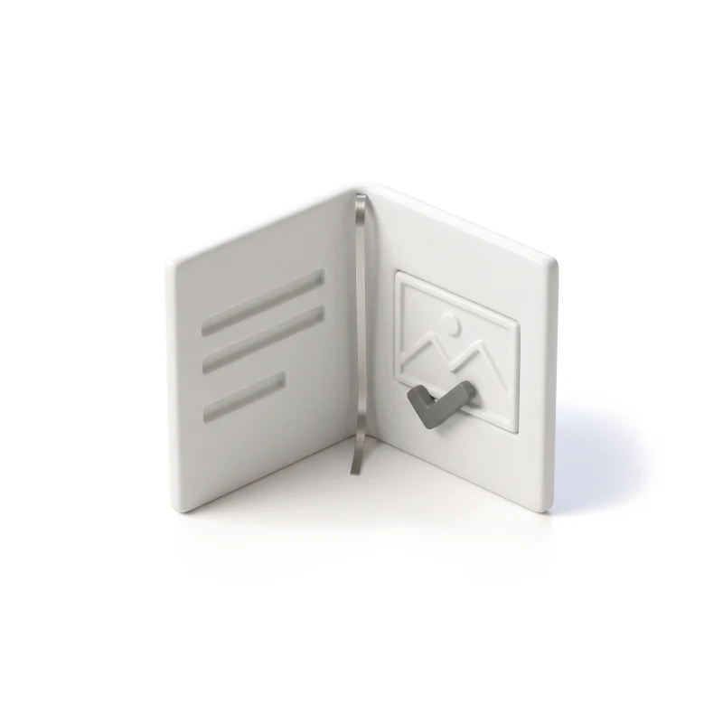 A half-open ceramic folder with carved rows on one page and a photo tile with a graphite check mark on the other.