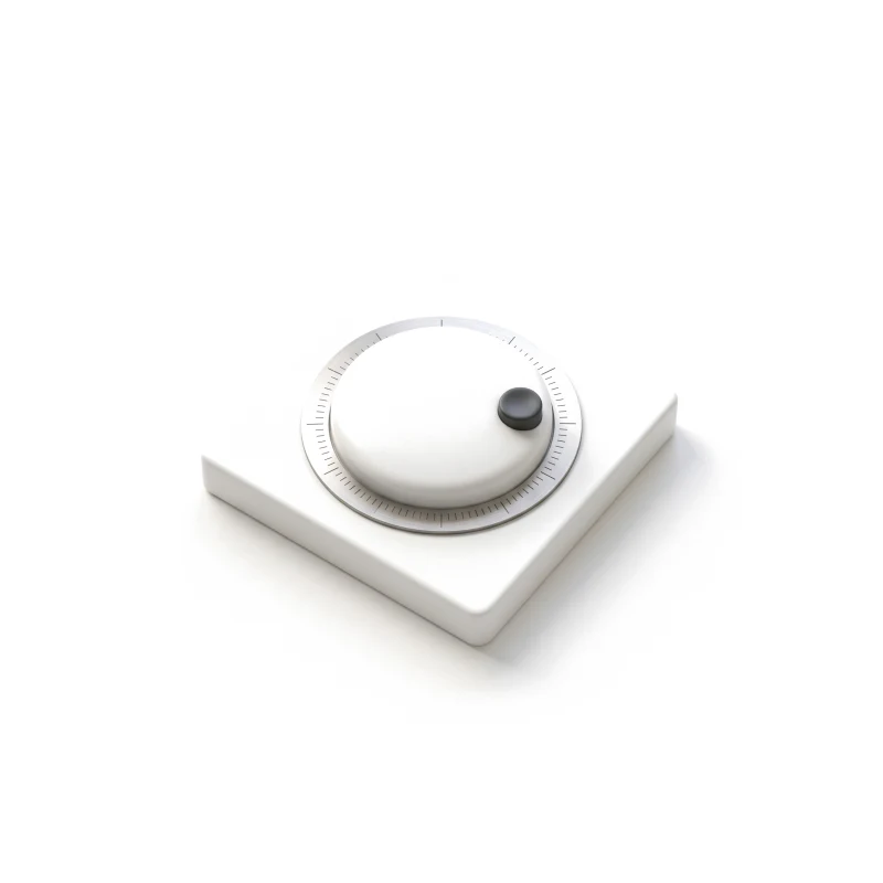A white ceramic thermostat dial on a square plate, ringed by a steel scale, with a small graphite knob.
