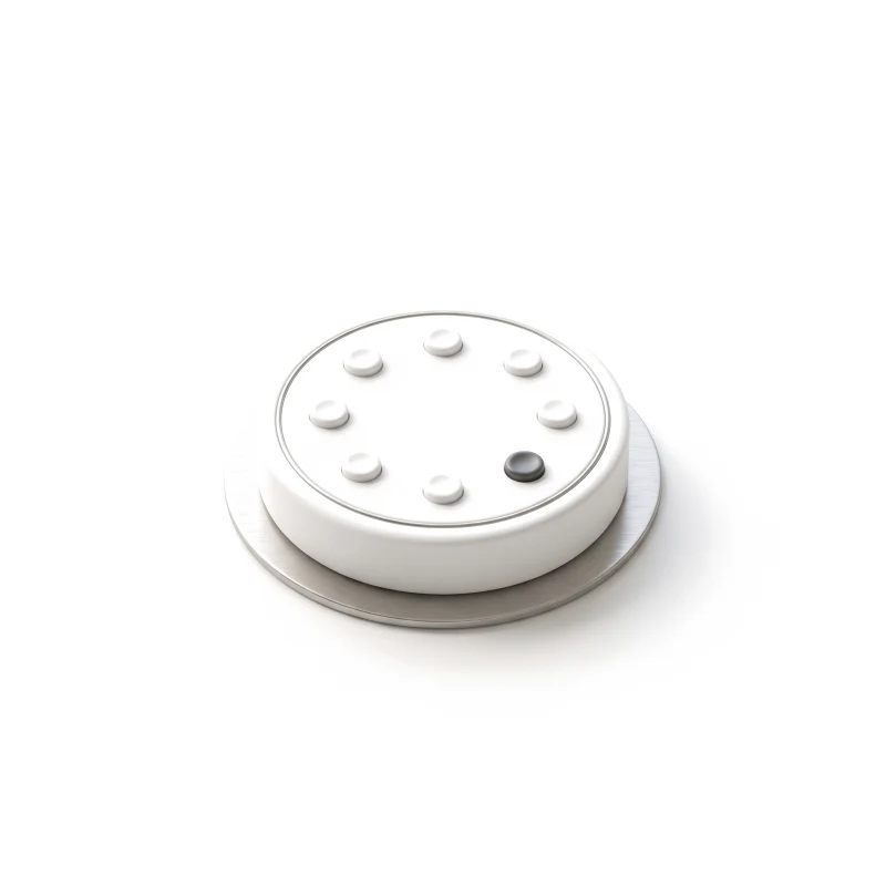 A white ceramic puck device on a brushed-steel plate, a ring of eight raised status dots on top, one in graphite.