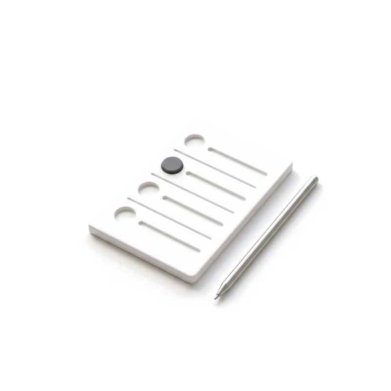 A white ceramic quiz card with carved answer rows, one round checkbox filled in graphite, a steel stylus beside it.