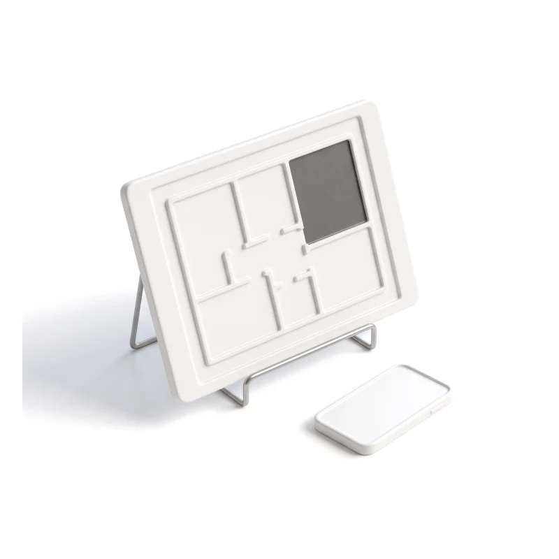 A ceramic tablet carved with a floor plan on a steel stand, one room graphite, a phone lying beside it.