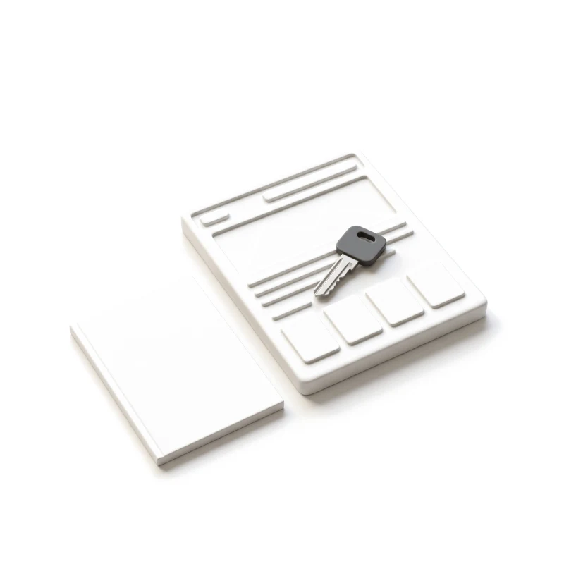 A steel key with a graphite head on a ceramic page slab, a closed ceramic booklet beside it.